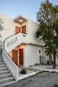 a white house with stairs leading up to it at Kanso Rooms in Galatás