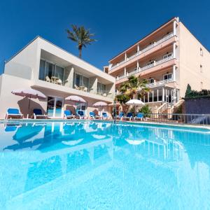 a swimming pool in front of a hotel at Hotel Venecia Paguera in Paguera