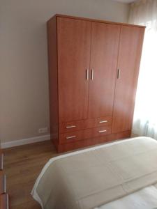 a large wooden cabinet in a bedroom with a bed at VUT 795 AS Apartamento Marqués de Teverga 10 in Oviedo