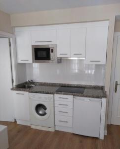 - une cuisine blanche avec un lave-linge et un four micro-ondes dans l'établissement VUT 795 AS Apartamento Marqués de Teverga 10, à Oviedo