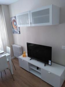 a living room with a flat screen tv on a white cabinet at VUT 795 AS Apartamento Marqués de Teverga 10 in Oviedo