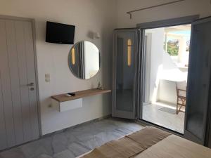 Habitación con espejo, mesa y ventana en Kostas & Joanna Studios, en Logaras