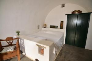 a bedroom with a white bed and a chair at Axion Studios in Aroniadika