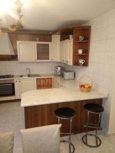 uma cozinha com um balcão e dois bancos de bar em Apartment Mihael - 4 persons em Vodnjan