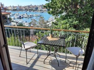 a balcony with a table and chairs and a view of a harbor at Apartments Rožić in Rab