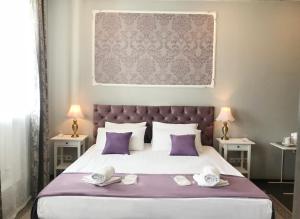 a bedroom with a large bed with purple pillows at N-House Hotel in Moscow