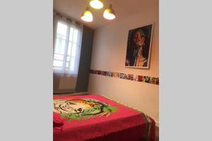 a room with a bed with a red blanket at APPARTEMENT STYLE POP ART avec GARAGE CENTRE HISTORIQUE BEZIERS in Béziers