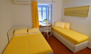 Habitación con 2 camas y mesa con ventana en Apart Seaview Piran, en Piran