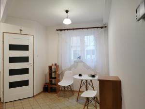 a room with a table and chairs and a window at WHITE Apartment in Jabłonna
