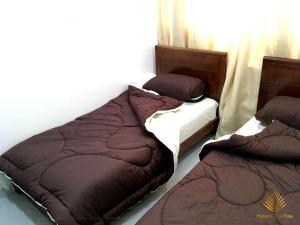 
a bed with two pillows and two nightstands at Hostel Les Pins Alger in Alger
