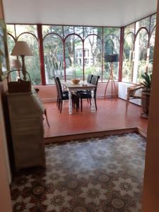 a dining room with a table and chairs and windows at Villa de Charme sur la Corniche in Sète +15 photos