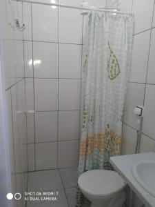 uma casa de banho com um WC e uma cortina de chuveiro em Pousada do Professor em Pirenópolis