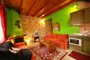 sala de estar con sofá rojo y paredes verdes en Petrino Rodo, en Karpenisi