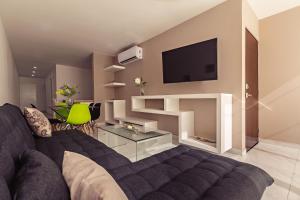 uma sala de estar com um sofá e uma televisão em Mararena Condos by Nah Hotels em Playa del Carmen