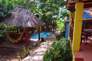 a resort with a swimming pool and a thatch hut at Los Volcanes, Playa el Coco in Escameca