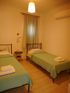 パレロスにあるKanellos luxury apartmentsのベッド2台と窓が備わる客室です。