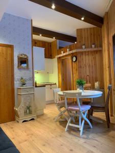 Casa Vacanza Roccaraso في روكاراسو: مطبخ وغرفة طعام مع طاولة وكراسي