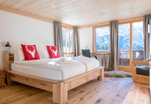 a bedroom with a large bed with red pillows at Chalet Ledibach in Wengen