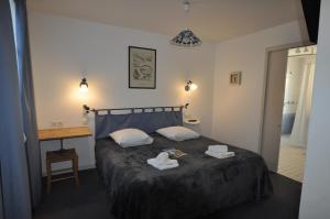 ein Schlafzimmer mit einem Bett und einem Tisch mit Handtüchern darauf in der Unterkunft Le Concept Hotel in Les Portes