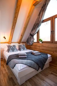 a bedroom with a large bed in a attic at Domek & Apartament Na Ogrodzie in Suche