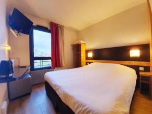 a hotel room with a large bed and a window at Hôtel Inn Design Resto Novo Chartres in Chartres