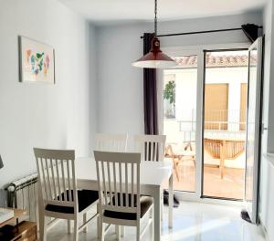 a white dining room with a white table and chairs at 2 bedroom apartment in the old town, close to the beach in L'Escala +24 photos