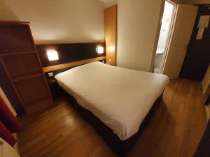 a bedroom with a large white bed in a room at Hôtel Inn Design & Restaurant Chartres in Chartres