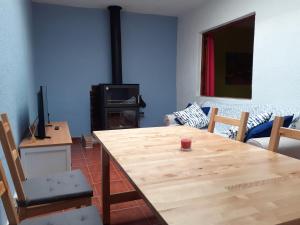 sala de estar con mesa de madera y TV en Sant Miquel, en Vilafamés