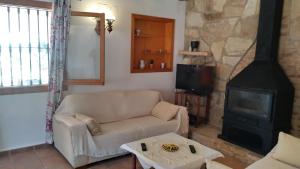 uma sala de estar com um sofá e um fogão em Larnella em Teulada