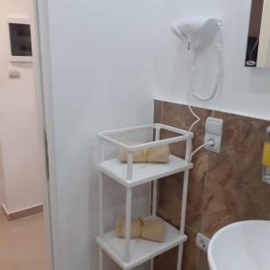 ein Badezimmer mit einer Dusche und einem Regal mit Handtüchern in der Unterkunft Apartman 4L in Kladovo