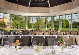 um salão de banquetes com mesas e cadeiras com toalhas de mesa brancas em The Lodges at Kilkea Castle em Kilkea