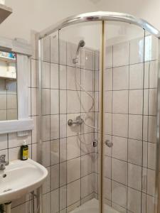 a shower with a glass door next to a sink at WHITE Apartment in Jabłonna