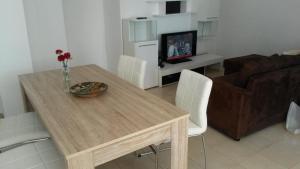 a living room with a wooden table and a couch at Apartment Miro in Prvić Šepurine