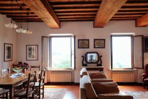 two images of a living room with a table and a couch at Hotel Santa Caterina in Siena