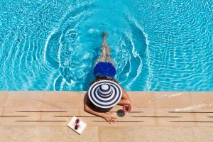 una persona en una piscina con sombrero en Finch Bay Galapagos Hotel, en Puerto Ayora