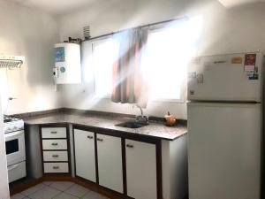a kitchen with a white refrigerator and a sink at Le Parc in Gualeguaychú