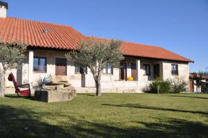 una casa con un árbol y un techo rojo en Quinta do Olival, en Vilas Boas