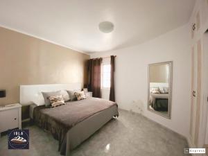 a bedroom with a bed and a large mirror at Old Town Puerto del Carmen in Puerto del Carmen