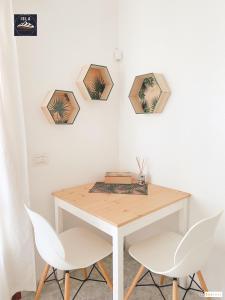 a dining room table with two chairs and two pictures on the wall at Old Town Puerto del Carmen in Puerto del Carmen