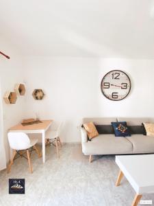 a living room with a couch and a clock on the wall at Old Town Puerto del Carmen in Puerto del Carmen