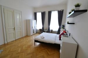 a bedroom with a bed and two windows at Apartment HVIEZDKO in Bratislava