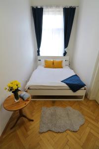 a bedroom with a bed and a table and a window at Apartment HVIEZDKO in Bratislava