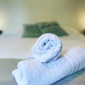 Una toalla enrollada encima de una cama en Hospedaje de la Costa en Tigre
