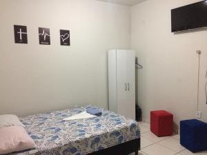 a bedroom with a bed and a white refrigerator at Apartamento Confortável Próx Unesp in Botucatu