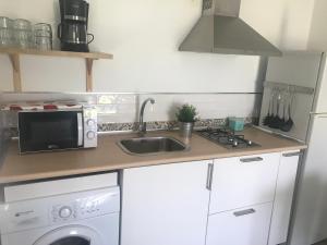 a kitchen with a sink and a microwave at La Casita de Laura in Bolonia