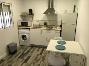 a kitchen with a refrigerator and a table and a sink at La Casita de Laura in Bolonia