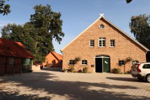 a large brick building with a green door at Ferien- und Reiterhof Klein Stavern in Stavern 