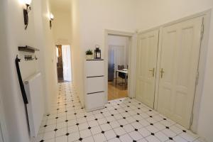 a hallway with a white and black tiled floor at Apartment HVIEZDKO in Bratislava
