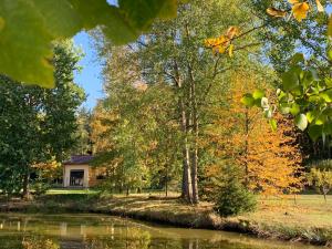 una casa junto a un río con árboles en Tiny Vacation, en Písek