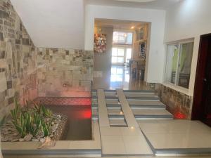 a lobby with stairs and a pond in the middle at Hotel Tijerinos in Boaco